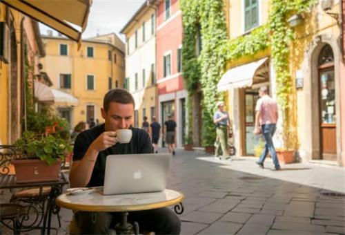 Digital nomad working on a laptop while drinking coffee at a street cafe in a historic Tuscan town