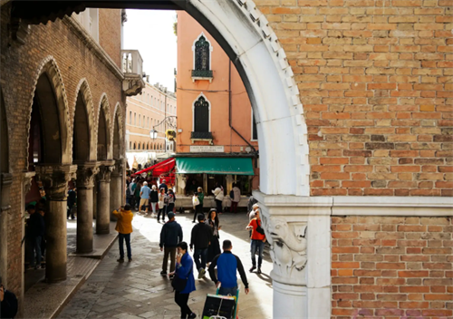 People walking through a Venetian street archway