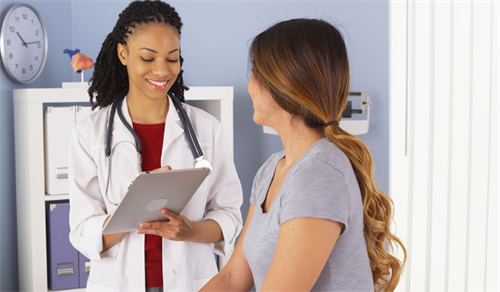 Female doctor consulting with a patient in a modern clinic, using a tablet