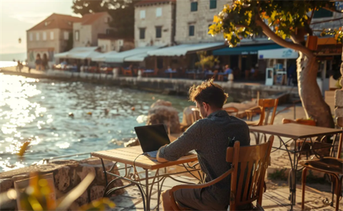 Digital nomad working on a laptop at a seaside cafe in Croatia