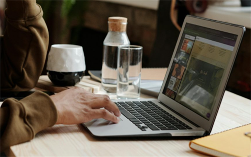 Person using a laptop at a cozy home office desk